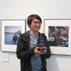 写真展会場での奥山さん。愛用のローライフレックスを手に